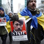 A man holds a sign in a protest against Russian military intervention in the Crimea region of Ukraine on March 2, 2014 in New York City.