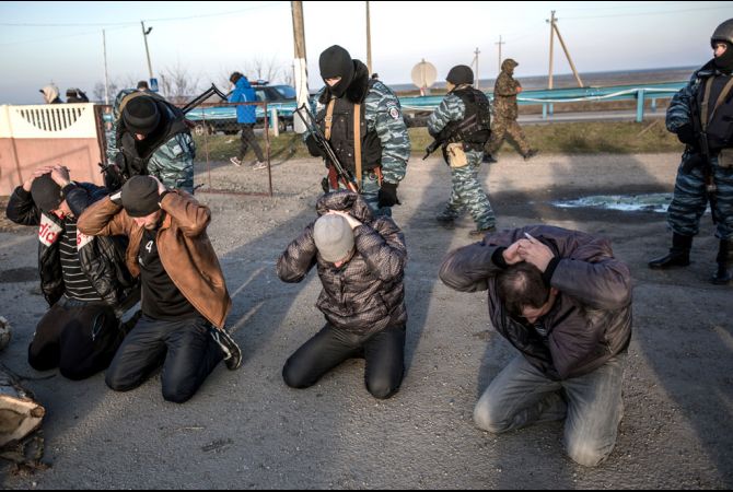 Russian border guards searching Ukrainians at the foot crossing into occupied Crimea