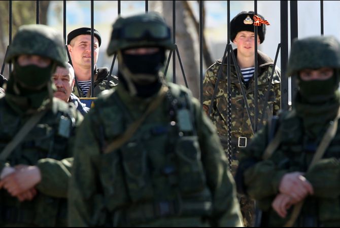 A Ukrainian base in Crimea surrounded by the "little green men," heavily armed troops wearing no ensignia to hide the fact that the troops were Russian special forces. February 2014