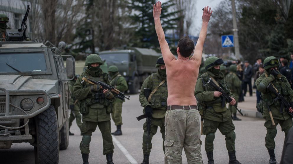 An unarmed Ukrainian man stands in protest in front of spetsnaz soldiers of Putin's occupation force capturing Crimea, February 2014.