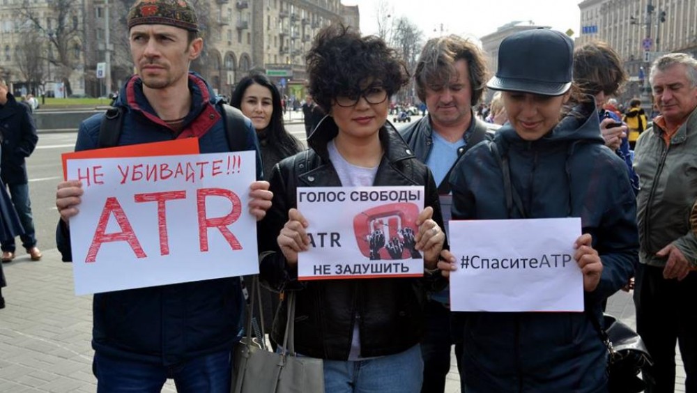 Protest signs say: "Don't kill ATR!!!", "ATR's voice of freedom will not be strangled", #SaveATR" (Image: rfi.fr)