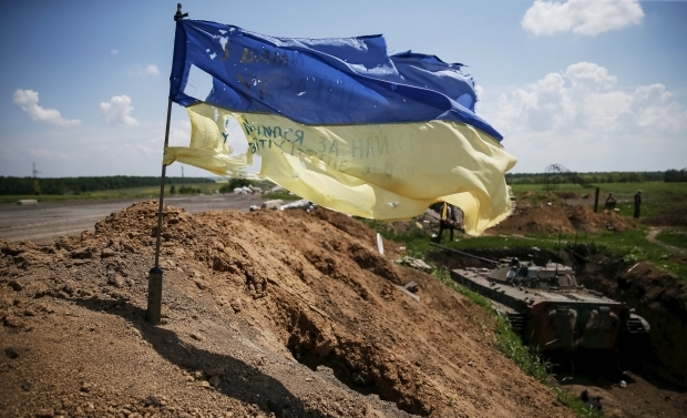 A flag at the positions of Ukrainian troops after the bombardment by heavy Russian artillery and multiple missile launchers in the town of Maryinka. June 3, 2015. (Image: Reuters)