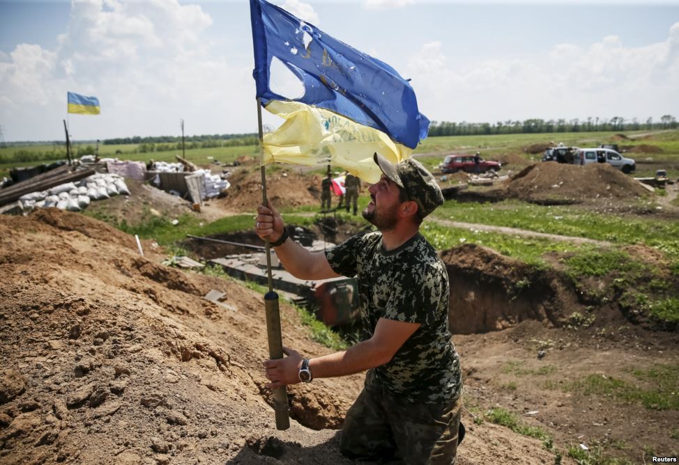 Ukrainian flag after the Russian attack on the positions of the Ukrainian troops in the town of Maryinka. June 5, 2015. (Image: Reuters)