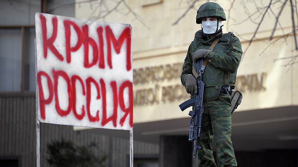 A Russian annexation force soldier on guard duty next to the captured Supreme Rada of Crimea in Simferopol in February 2014. Next to him a hand-made sign saying "Crimea, Russia." (Image: kommersant.ru)