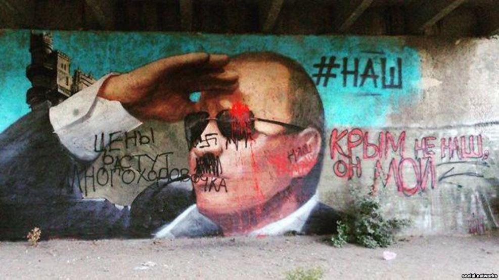 A propagandist mural of Putin in occupied Yalta, Crimea sported a hashtag "#НАШ" ( Russian for "ours") to claim that Crimea is now Russian. The graffiti by Crimean residents that quickly covered it disagreed with the Kremlin statement and expressed what they think about Putin's Crimean Anschluss. May 2015 (Image: social networks).