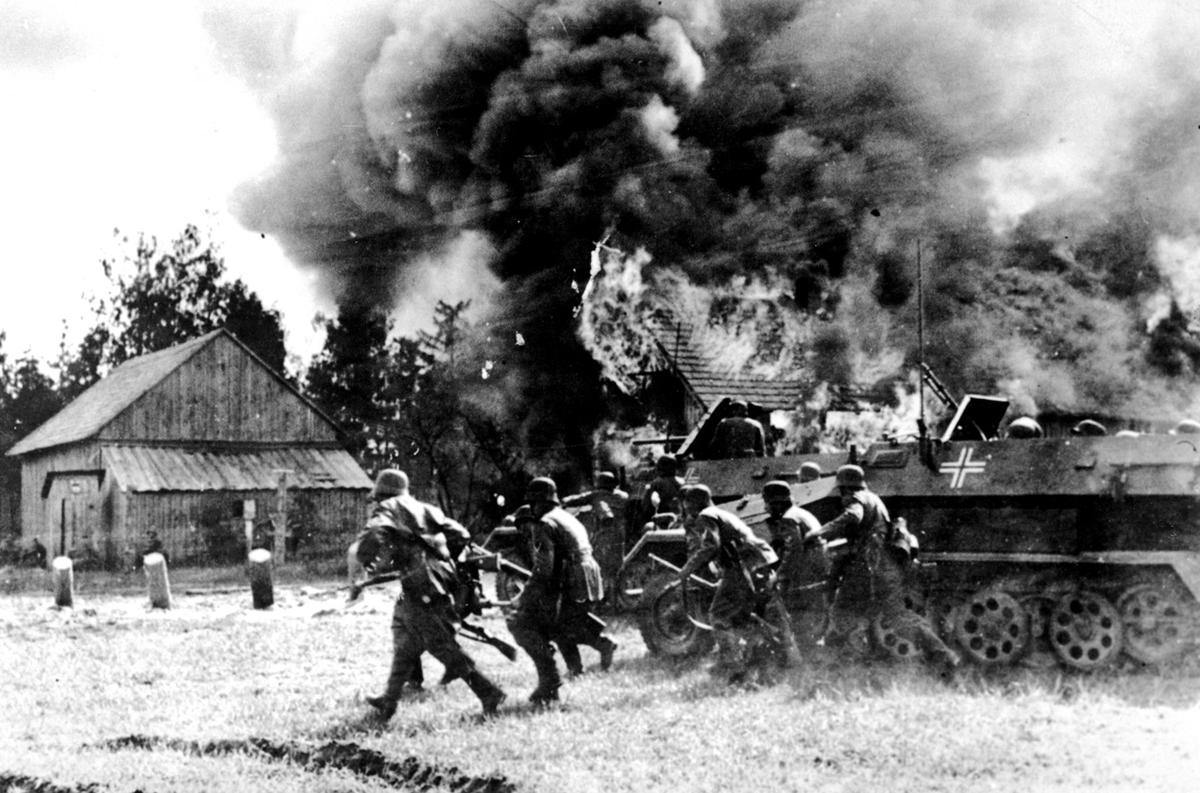 German soldiers, supported by armored personnel carriers, move into a burning Russian village at an unknown location during the German invasion of the Soviet Union, on June 26, 1941. (Image: AP)
