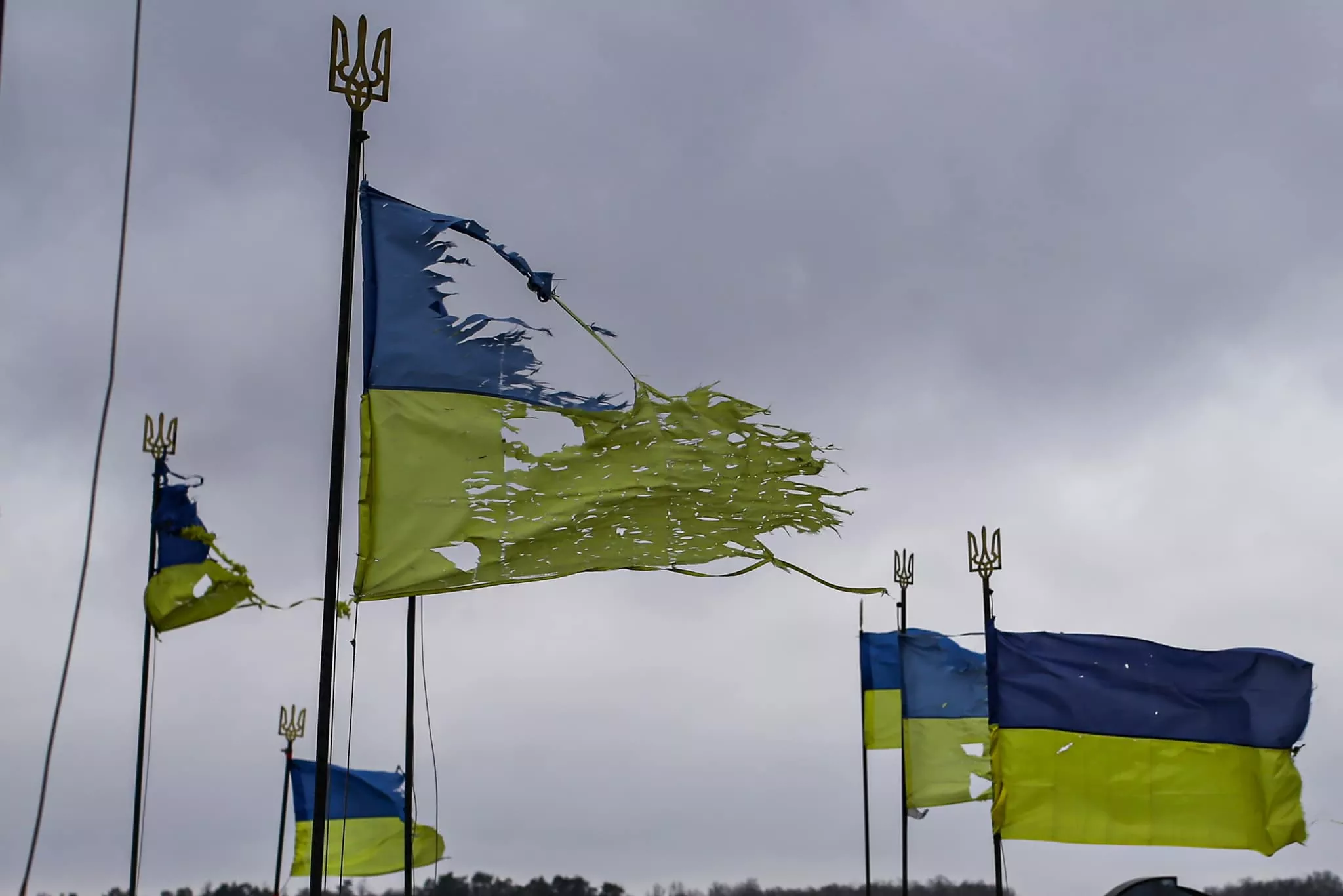 Ukrainian national flags shot at by Russian invaders but still flying over damaged gravestones of Ukrainian soldiers at the Yatsevo cemetery in Chernihiv after breaking the Russian siege. April 6, 2022. The Russo-Ukrainian War 2014-present. Photo: Stas Yurchenko via FB.