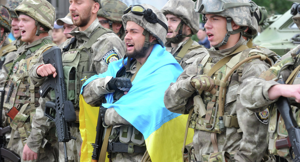 Ukrainian soldiers with a national flag singing the anthem (Image: AFP 2016)