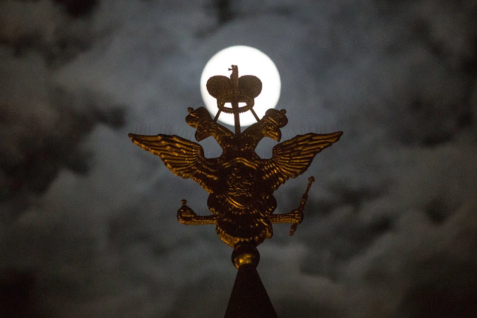 Russian state crest in front of full moon (Image: vedomosti.ru)