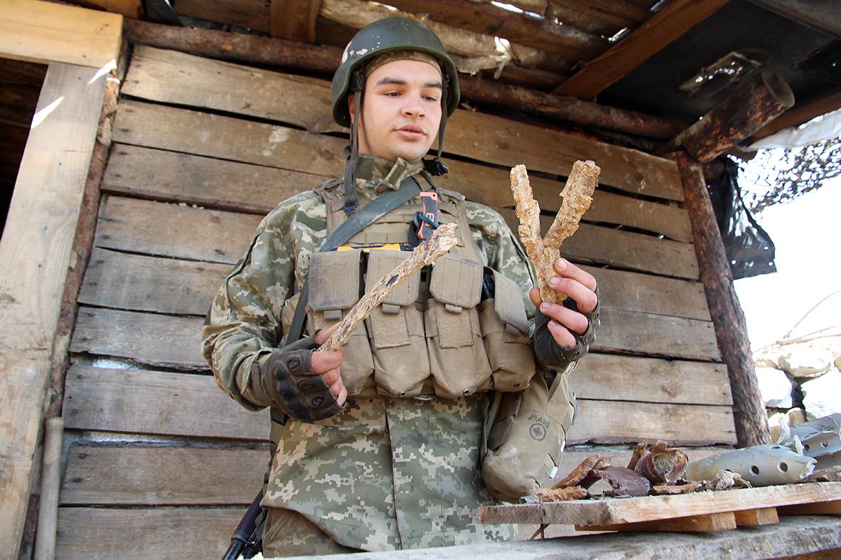 Ukrainian soldiers in war zone display enemy “trophies” gathered after night attacks