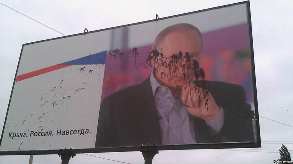 A Putin billboard with a propagandist slogan "Crimea. Russia. Forever" installed in the Crimean city of Kerch after the Russian occupation of the Ukrainian peninsula defaced with black paint. September 2015 (Photo: social media)