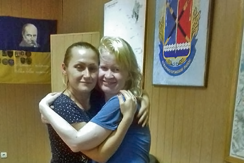 Liudmyla Surzhenko (right) and civil volunteer Kateryna Artemenko embracing each other as Liudmyla released