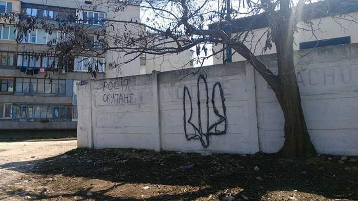 Suffering repressions and unable to show open protest against the Russian occupation under the threat of years of imprisonment, Crimeans resort to posters and graffiti. This graffiti in the annexed city of Sevastopol says "RUSSIA - OCCUPIER" and features a Ukrainian state coat of arms. The picture was taken by Twitter user @SectorCrimea on March 26, 2019.