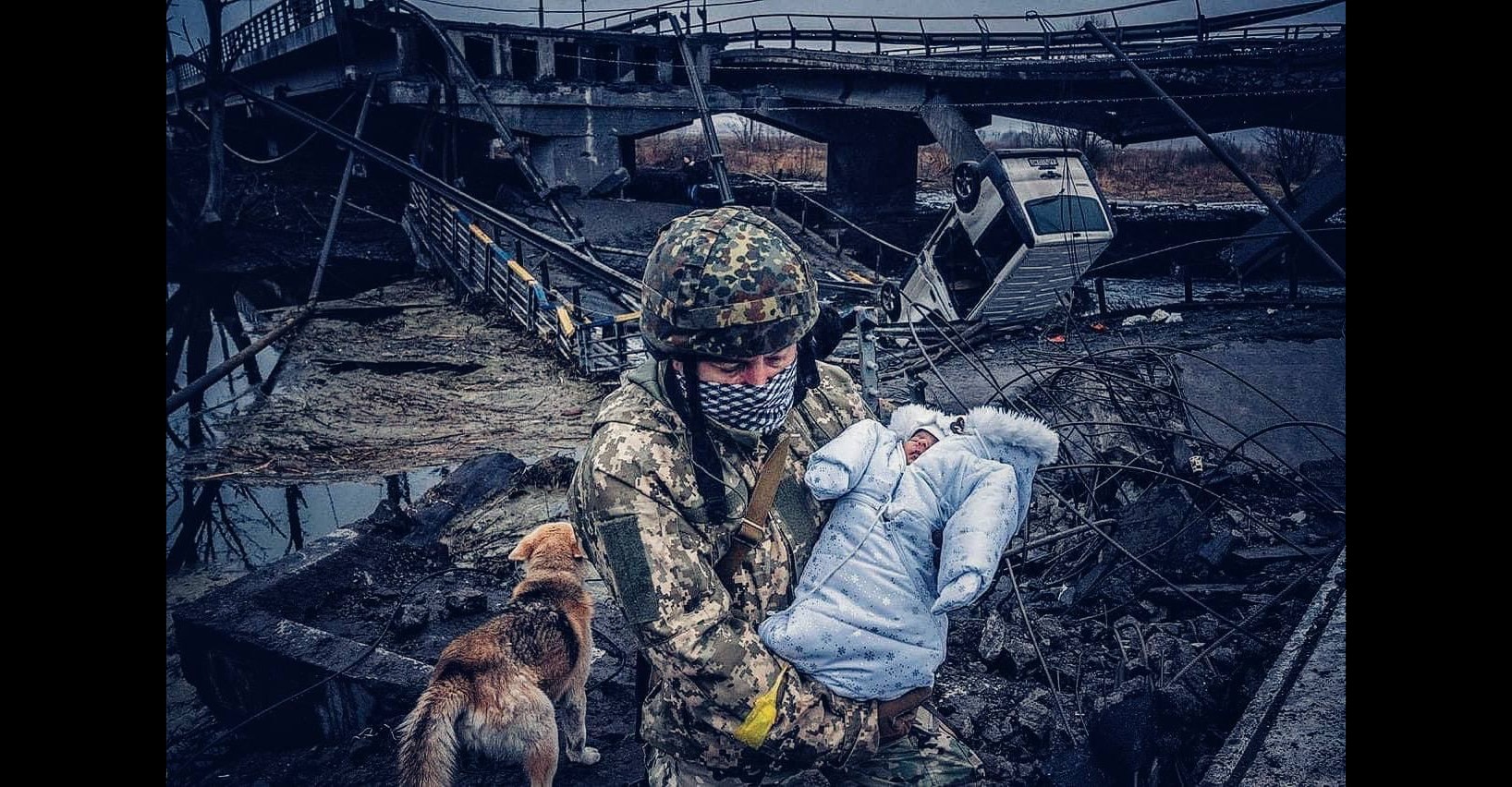 Ukrainian defender carries a baby over a river using the remains of a bridge destroyed by Russian bombardment in an area of continued Russian attacks. March 4, 2022. The Russo-Ukrainian War (2014-present). Credit: Ukrainian Freedom