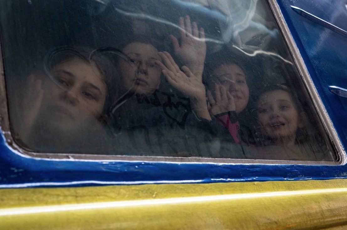 Four daughters wave goodbye to their father as they head westbound towards Lviv while he stays behind in Kyiv. Photo by Wolfgang Schwan. 4 March 2022. ~