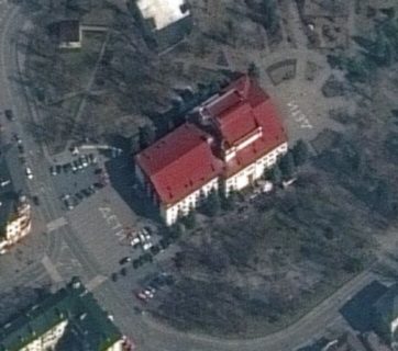 The Mariupol Drama Theater before it was bombed by Russian airplanes. Two giant white signs with the Russian word for "children" are visible on the opposite sides of the building. Satellite photo by Maxar Technologies