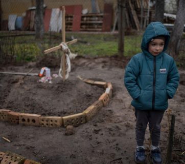 A 6 year old boy stands near the grave of his mother killed by Russian troops and buried in the yard of their house. April 5, 2022. Bucha, Kyiv region, Ukraine. The Russo-Ukrainian War (2014-present). Source: Dattalion