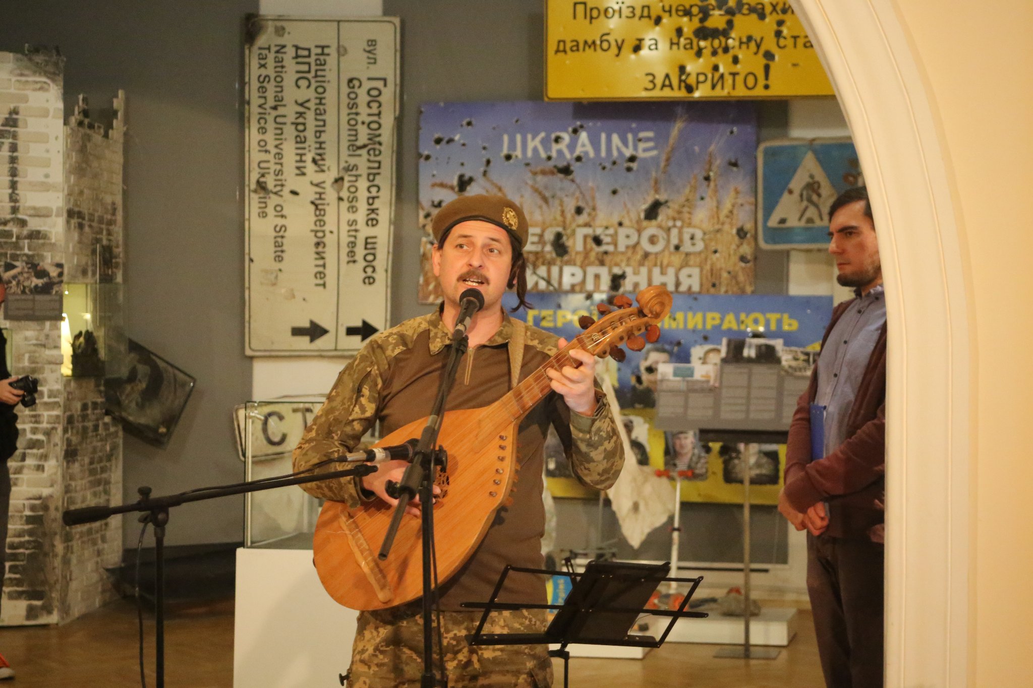 Taras Kompanichenko singing during the exhibition “Invasion, Kyiv shot” ~