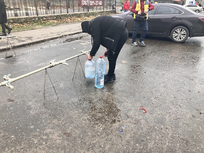 A resident of Mykolaiv getting water. Photo by Zarina Zabrisky. ~