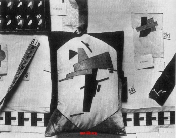 Photo from the exhibition of decorative art from Verbivka. In the center lies a pillow with embroidery by the sketch of Kazymyr Malevych (Malevich). 1917. Photo: Ukrlib.org ~