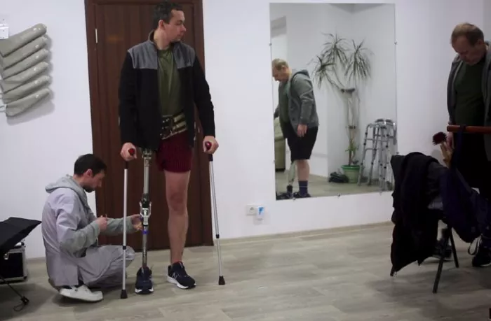 Prosthetist Yura Yaskiv adjusts Dmytro’s prosthetic leg ~