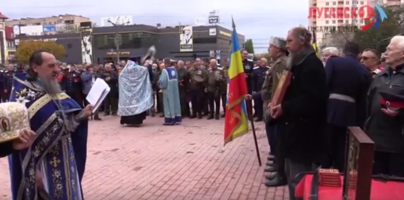 Pavel Batarchukov listens to Luhansk residents taking an oath of allegiance to the “Great Don Army,” the military formation of Russia’s puppet “LNR” and “DNR.” Screenshot from video ~